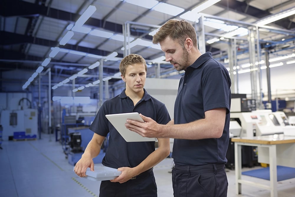 Manufacturing management looking at tablet