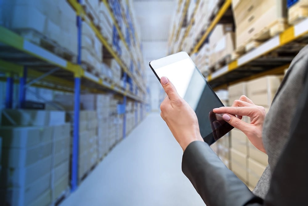 Business owner in warehouse on iPad